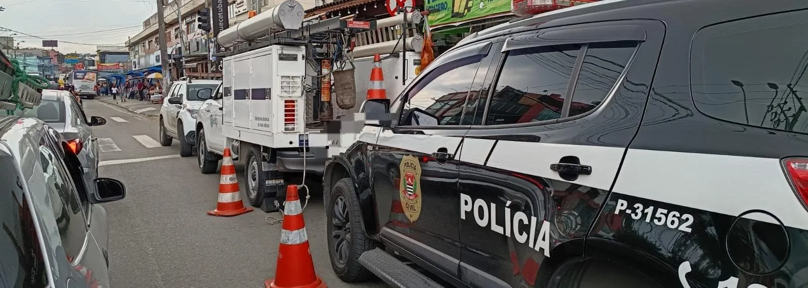 Agentes da polícia e técnicos da EDP inspecionam a rede elétrica em um açougue onde furto de energia foi detectado.