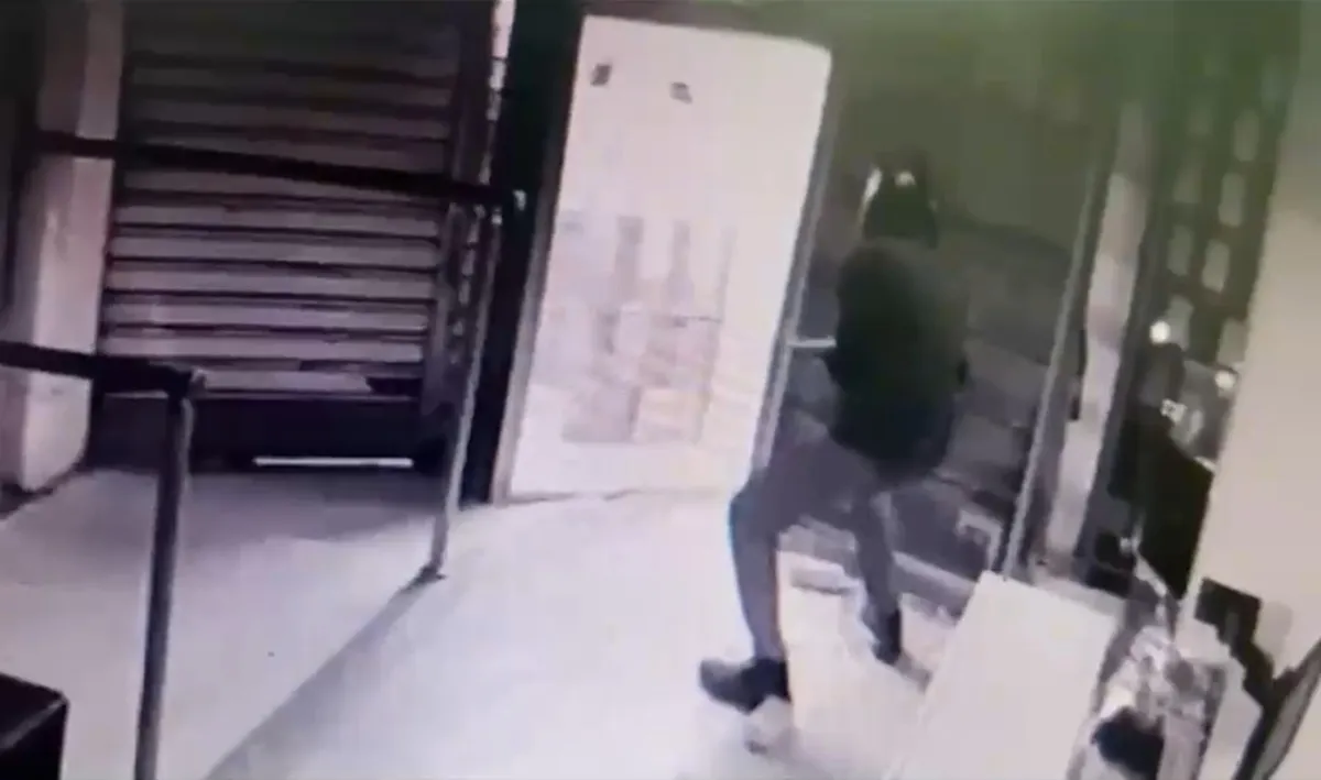 Câmera de segurança noturna flagrando dois indivíduos em uma moto em frente a uma loja de eletrônicos no centro de Campos, após um furto rápido.