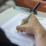 Jovens preenchendo provas do vestibular Fuvest