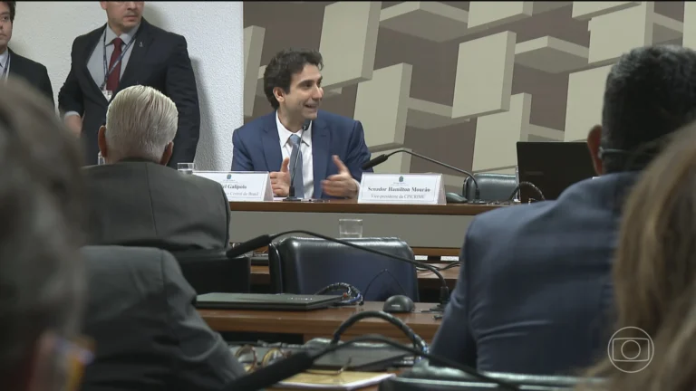 Gabriel Galípolo fala em CPI, com microfones à frente e fundo de plenário.