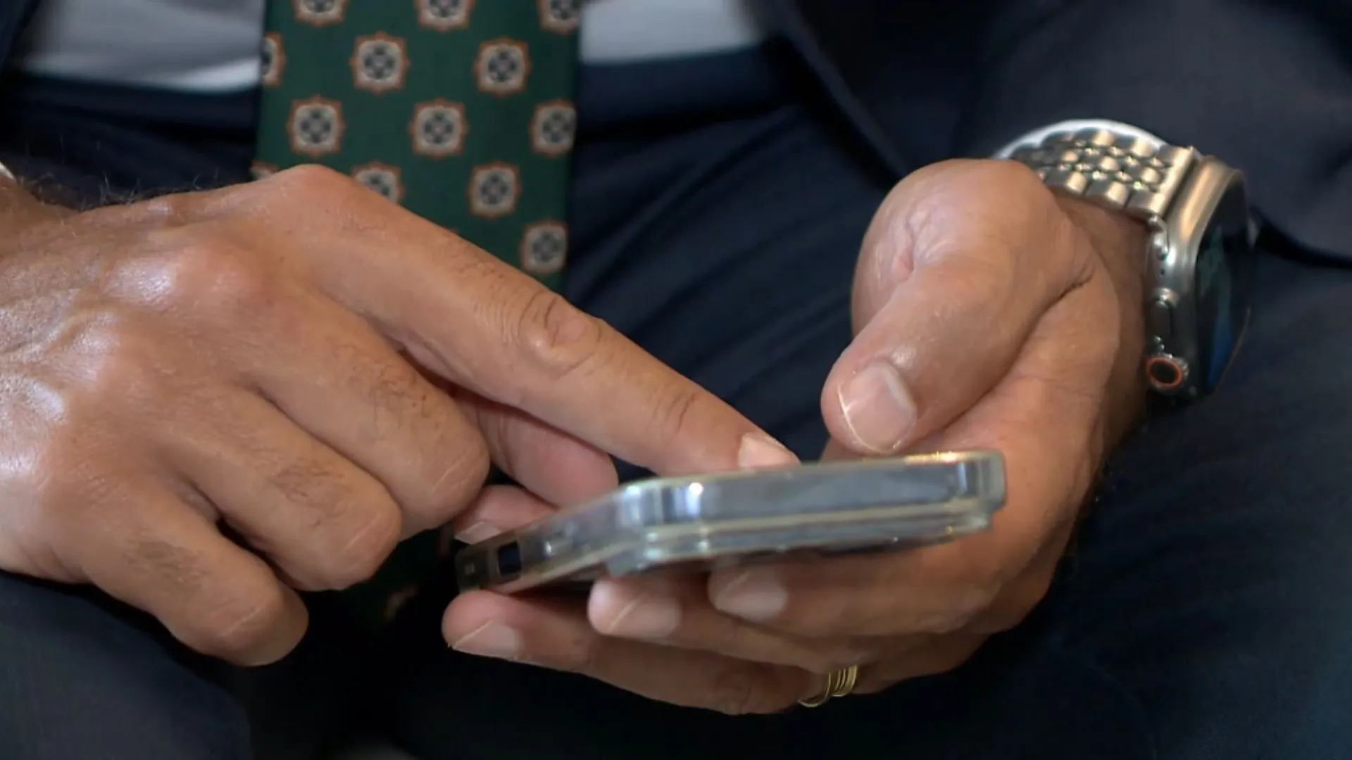 Pessoa olhando para o celular com expressão de preocupação, representando um golpe digital e a necessidade de proteção contra fraudes com inteligência artificial.