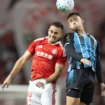 Escudos do Grêmio e Internacional lado a lado, com expressão de preocupação, simbolizando a crise e a luta contra o rebaixamento no Brasileirão.