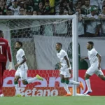Jogador do Guarani em partida de futebol, mostrando a determinação do ataque em marcar um gol.