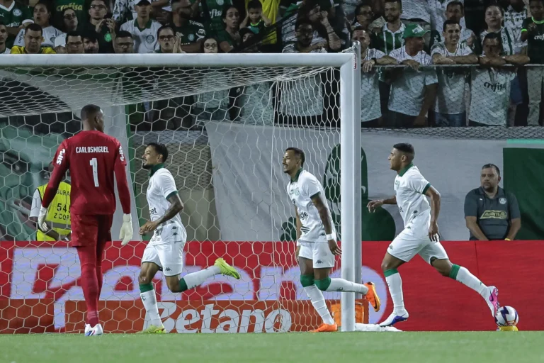 Jogador do Guarani em partida de futebol, mostrando a determinação do ataque em marcar um gol.