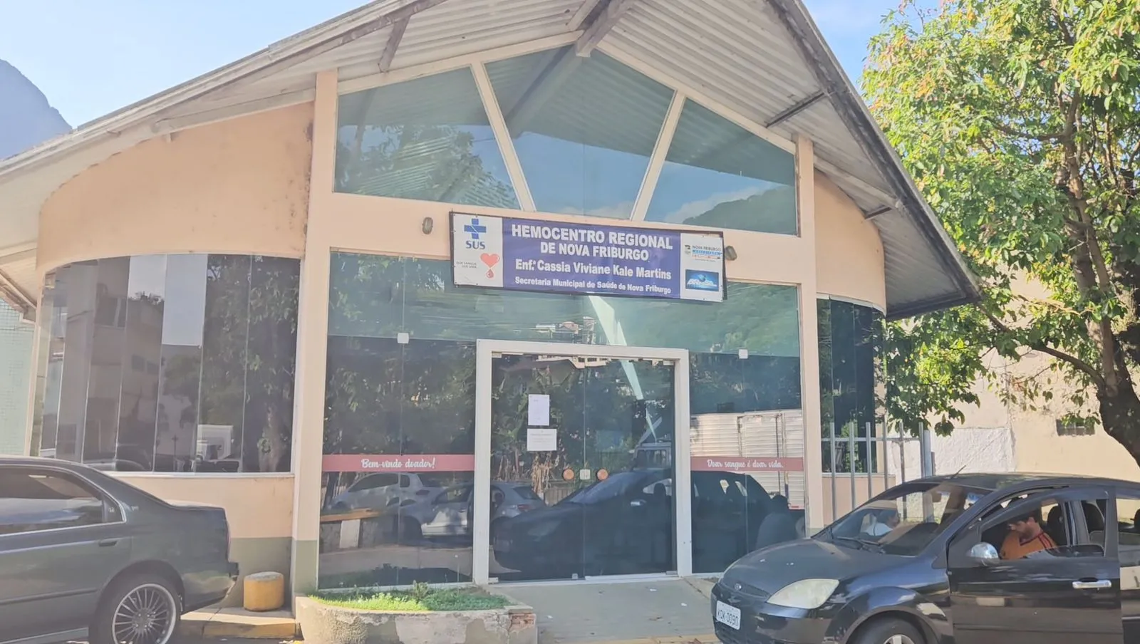 Grupo de doadores de sangue em Nova Friburgo, recebendo atendimento de enfermeiros em um ambiente hospitalar.