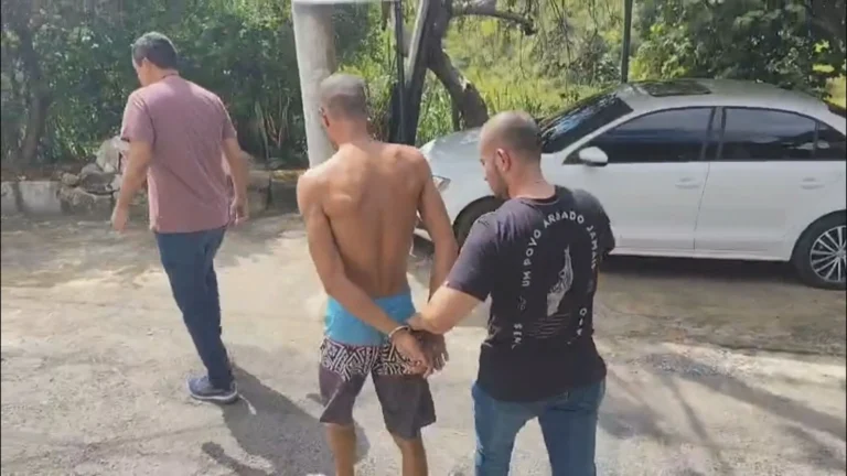 Mão segurando placa 'Denuncie' contra violência de gênero