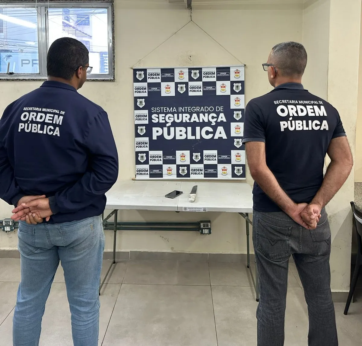 Policial devolvendo celular recuperado para motorista de aplicativo em Volta Redonda