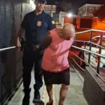 Homem algemado sendo preso pela Guarda Civil em rua escura, Ribeirão Preto