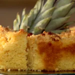 Cuca de abacaxi dourada com farofa e pedaços de abacaxi