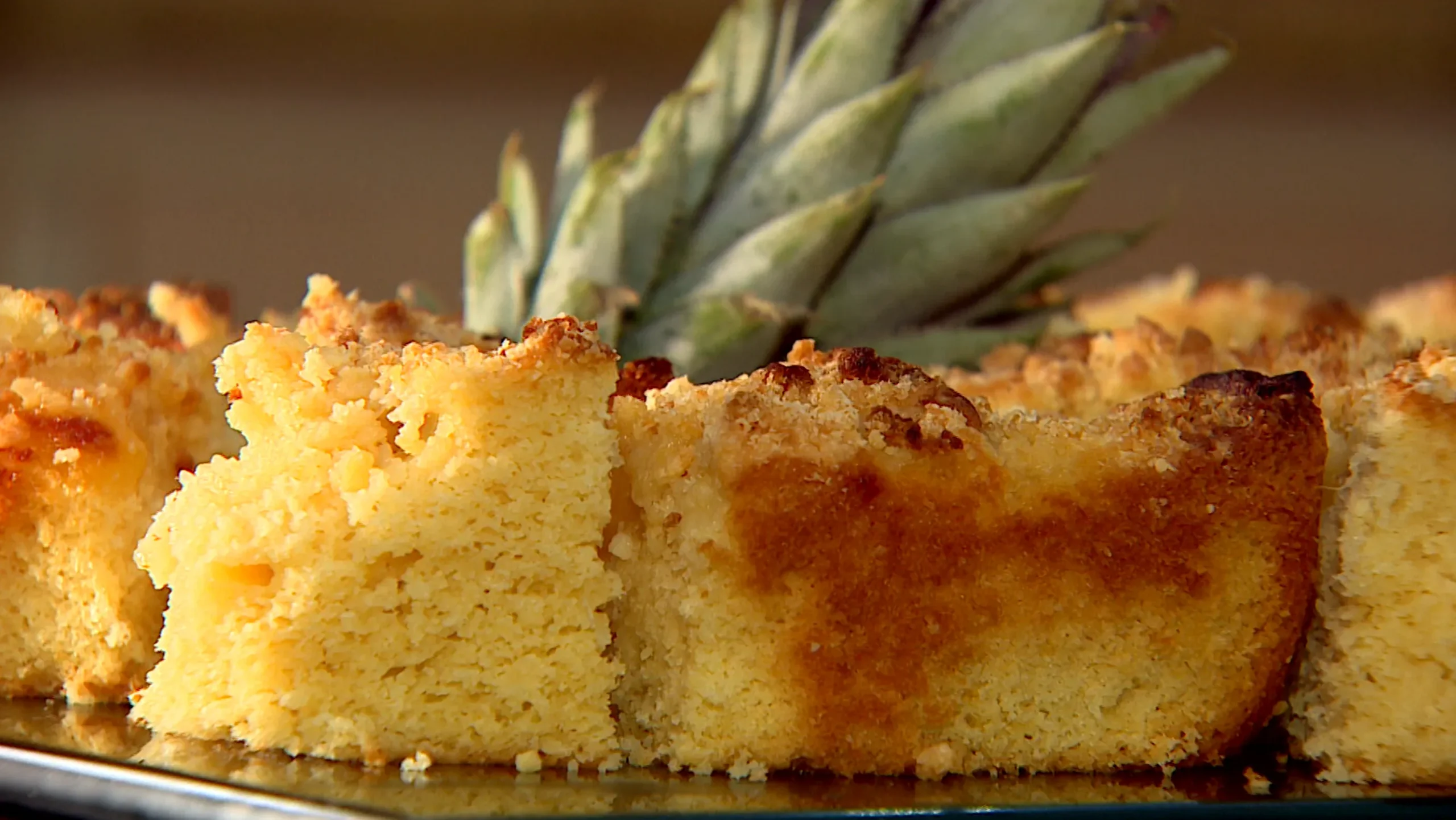 Cuca de abacaxi dourada com farofa e pedaços de abacaxi