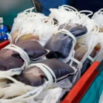 Pessoa doando sangue com enfermeira, campanha de doação em hospital