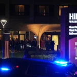 Fachada do Washington Hilton à noite, com luzes acesas e carros passando na rua