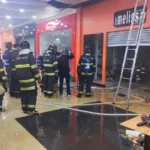 Loja de calçados atingida por incêndio no Bauru Shopping, com bombeiros e fumaça
