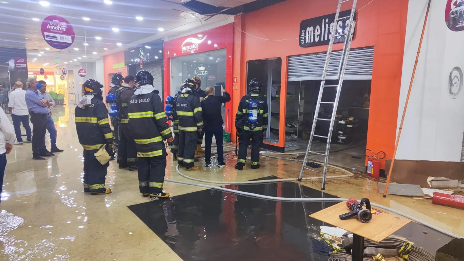 Loja de calçados atingida por incêndio no Bauru Shopping, com bombeiros e fumaça