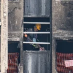 Idosos sendo ajudados em prédio após incêndio em Hong Kong