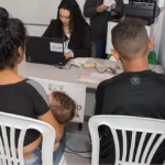 Família assinando documentos em mutirão de paternidade em Belo Horizonte