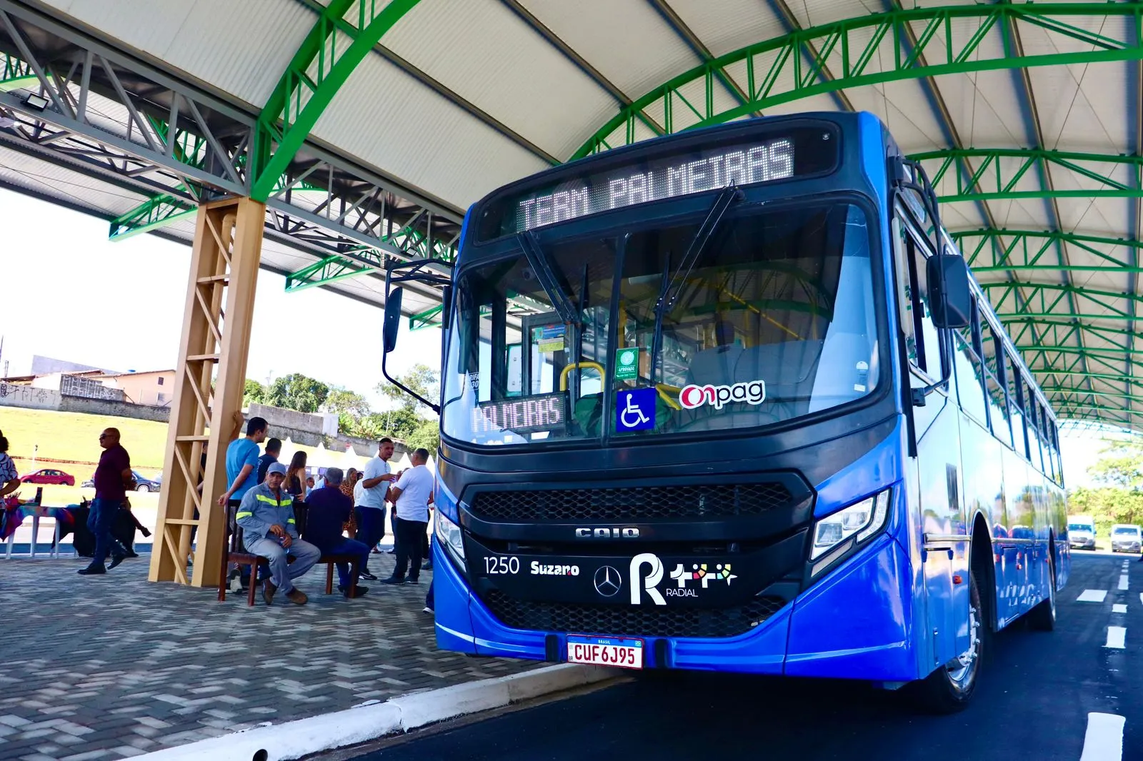 Grupo de estudantes universitários e técnicos em Suzano, com mochilas, aguardando transporte público com o Passe Livre Estudantil.