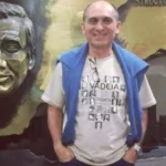 Rua noturna em Niterói com luzes de polícia e fita de isolamento, cena do crime de Mestre Paulinho Sabiá