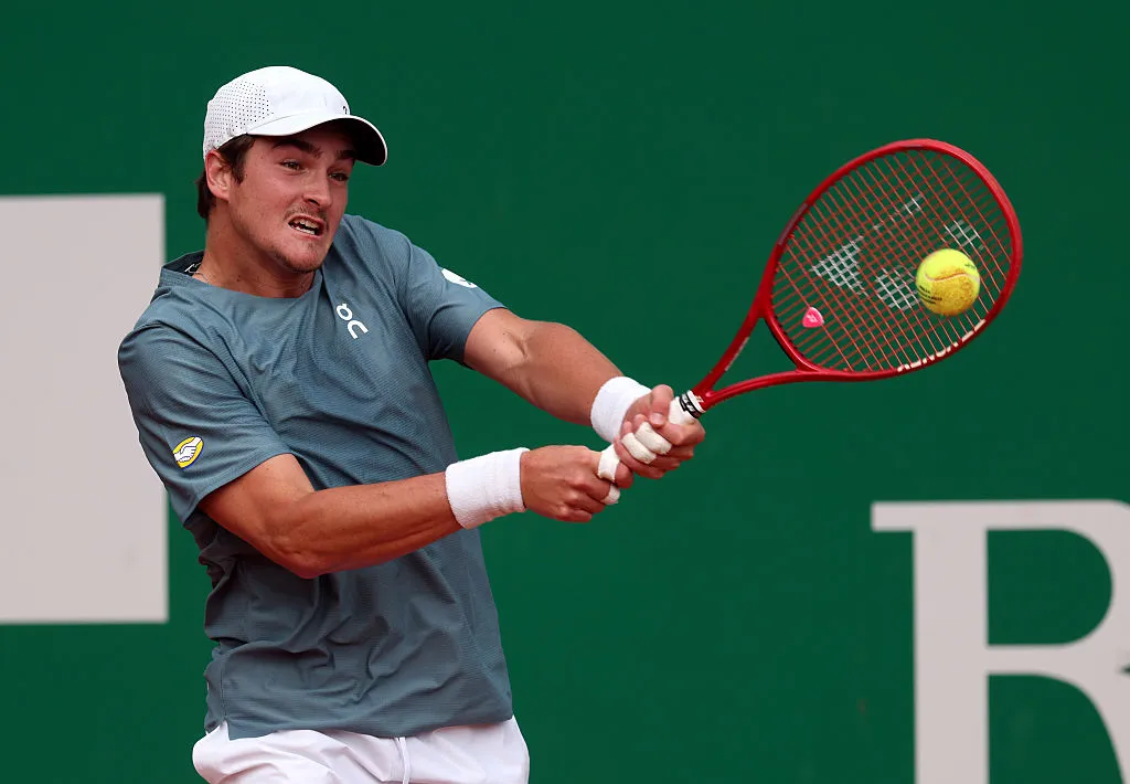 Tenista João Fonseca em quadra de saibro, jogando contra Arthur Rinderknech no Masters 1000 de Monte Carlo.