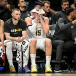 Jogador Jaden McDaniels marcando Jamal Murray em jogo dos playoffs da NBA.