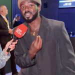 Jonathan Azevedo em cenário de Carnaval na Sapucaí, promovendo nova série