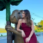 Jornalista turca Cansel Kemiksiz sorrindo ao lado de uma capivara em Barra Mansa, RJ