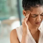 Jovem sentindo dor de cabeça, sinal de alerta para AVC