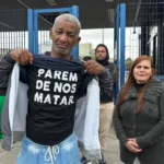 Pais de Gabriel Renan, jovem negro assassinado, em frente ao fórum de justiça.