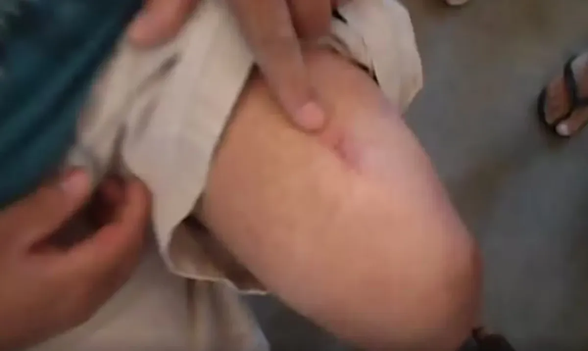 Documento legal sendo examinado, com fundo de presídio, representando a investigação da operação em Presidente Prudente.