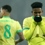 Jogador de futebol lesionado no campo, com dor na coxa direita, representando uma lesão grau 4