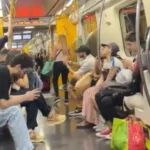 Trem da Linha Amarela parado com passageiros na estação Pinheiros, São Paulo