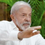 Pessoa endividada com celular e ícone de apostas, em cenário de refinanciamento de dívidas governamental.