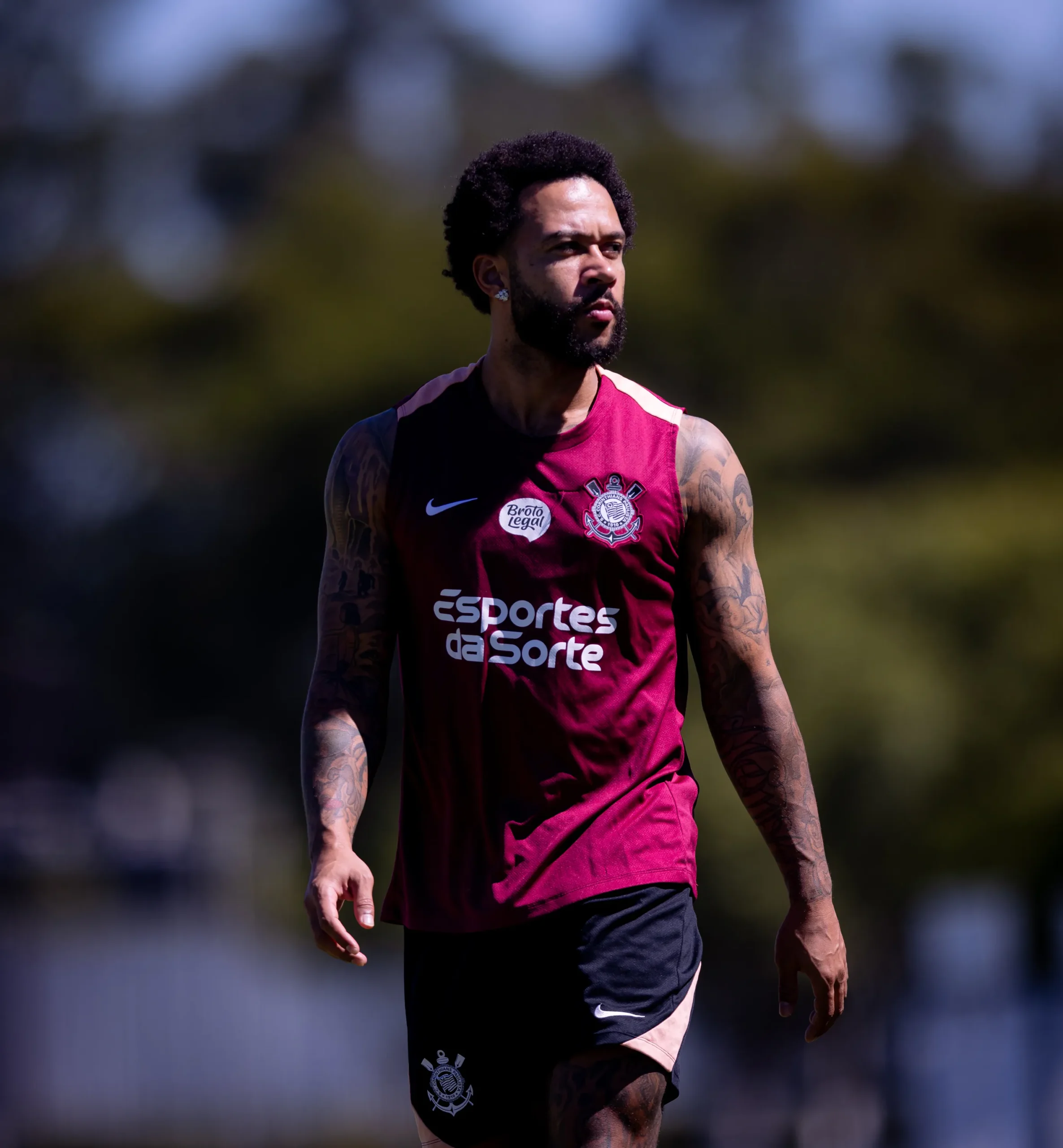 Foto de Memphis Depay, jogador do Corinthians, em campo no CT Joaquim Grava, vestindo uniforme de treino.