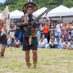 Grupo de indígenas Guarani em Maricá dançando e expondo artesanato durante celebração