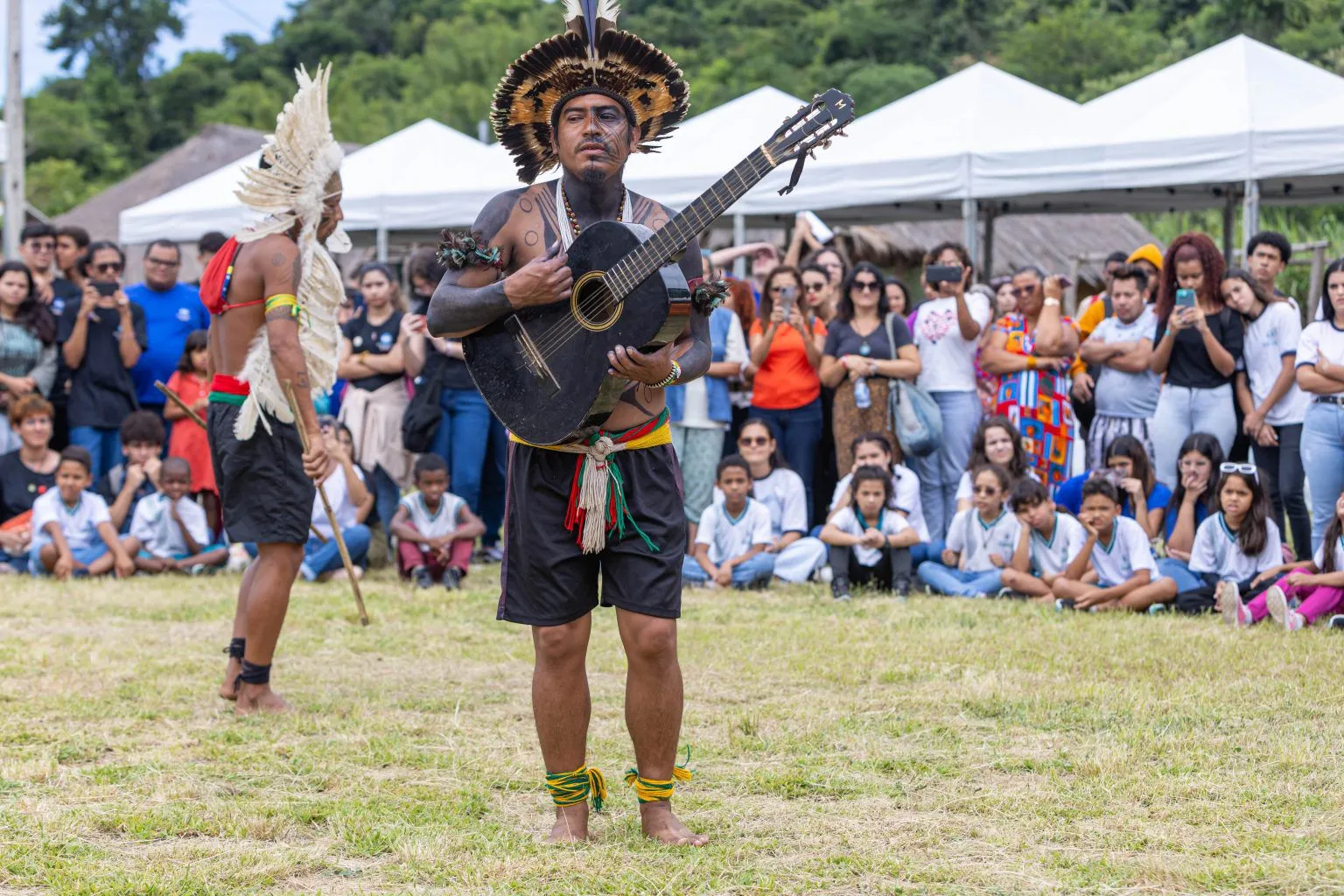 Grupo de indígenas Guarani em Maricá dançando e expondo artesanato durante celebração