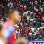 Jogadores do Bahia em campo na Arena Fonte Nova durante partida, representando o desempenho do Bahia em casa e fora.