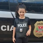 Criança feliz com policiais civis em sua festa de 7 anos