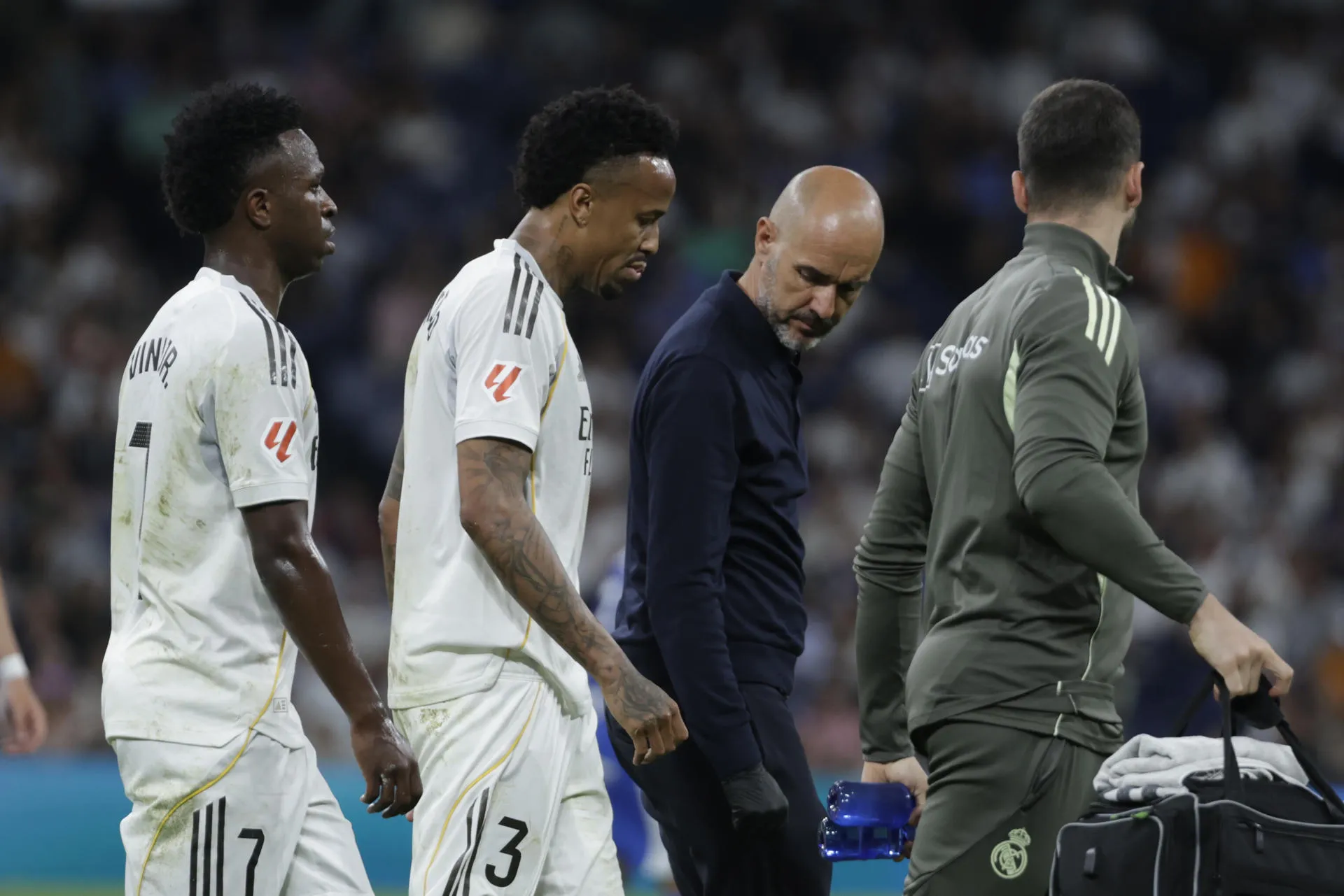 Médico examinando lesão de Éder Militão na perna esquerda, fibrose muscular, recuperação de lesão de Éder Militão, exame de joelho de jogador de futebol