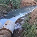 Esgoto aberto em rua de Itaperuna com obra inacabada e resíduos