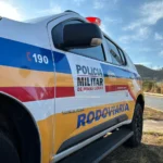 Foto aérea de acidente entre carro e carreta na rodovia AMG-1635, Lavras, com veículos danificados e equipes de emergência.