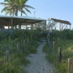 Quiosques na Praia da Reserva, Rio de Janeiro, com vegetação de restinga e faixa de areia