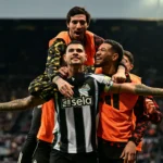 Foto de Bruno Guimarães, jogador de futebol do Newcastle, comemorando um gol em campo