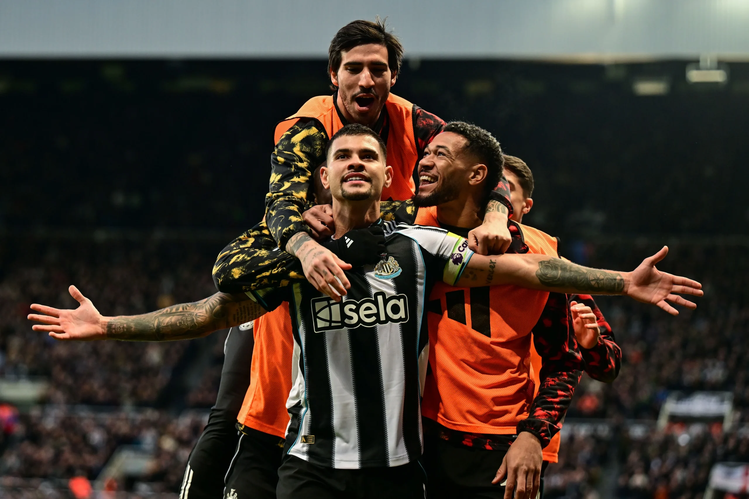 Foto de Bruno Guimarães, jogador de futebol do Newcastle, comemorando um gol em campo