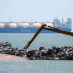 Estreito de Malaca com navios de carga, pôr do sol e costa