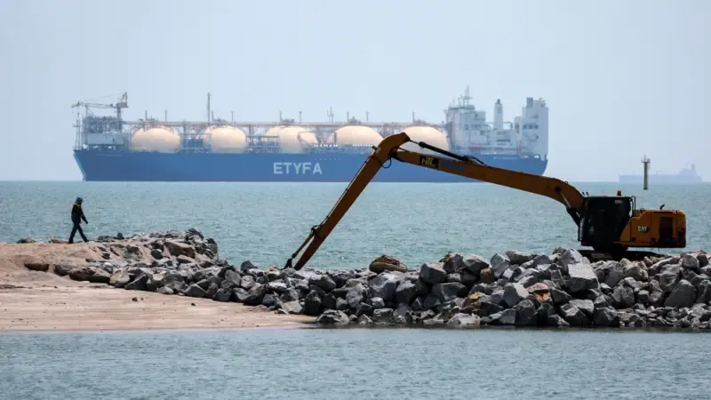 Estreito de Malaca com navios de carga, pôr do sol e costa