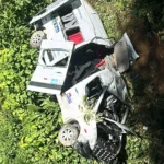 Van branca tombada em ribanceira após acidente na RJ-155 entre Angra dos Reis e Rio Claro, com socorristas e vítimas.