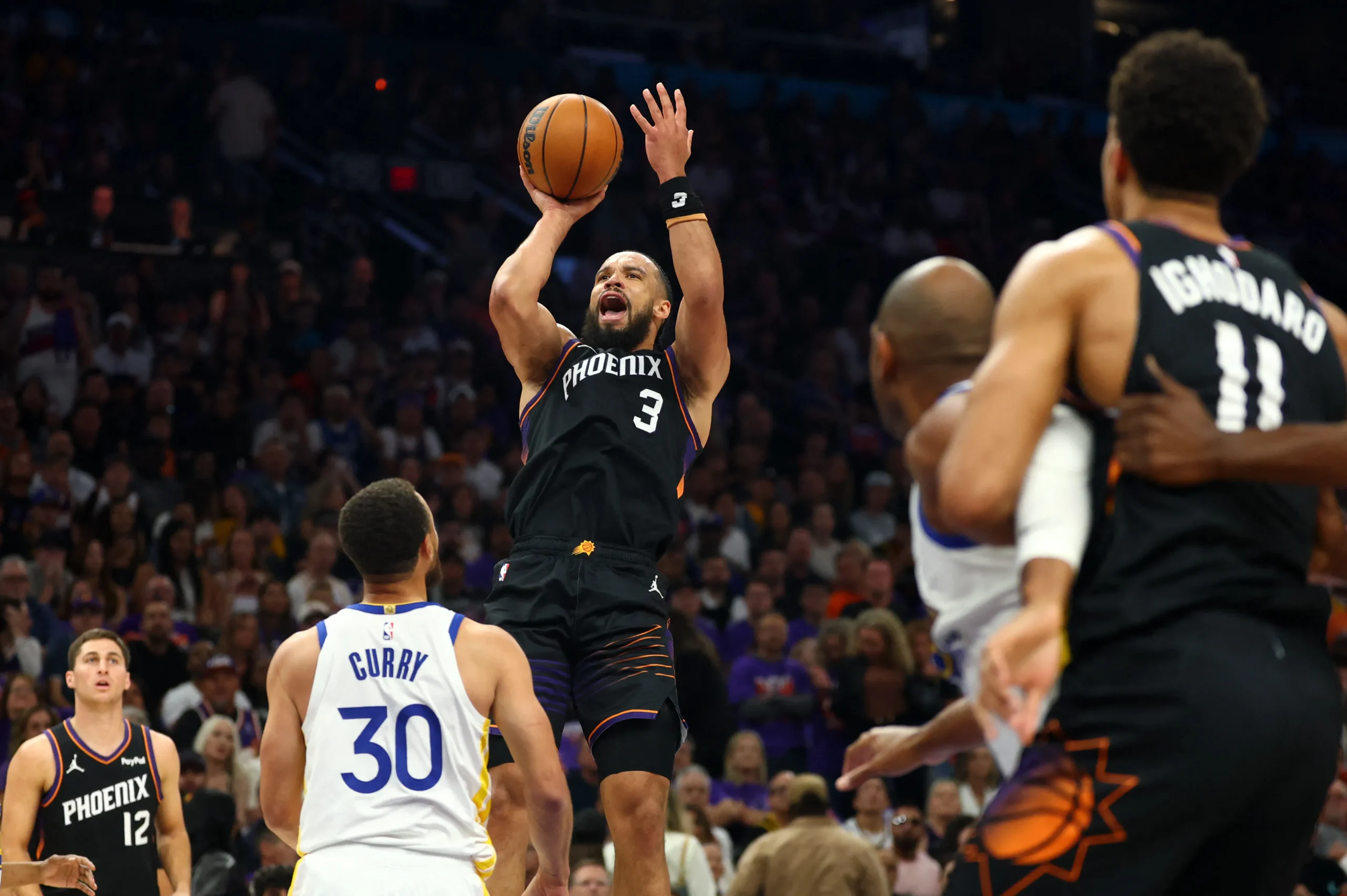 Jogadores do Magic e Suns em quadra disputando a bola nos playoffs da NBA, com torcida ao fundo