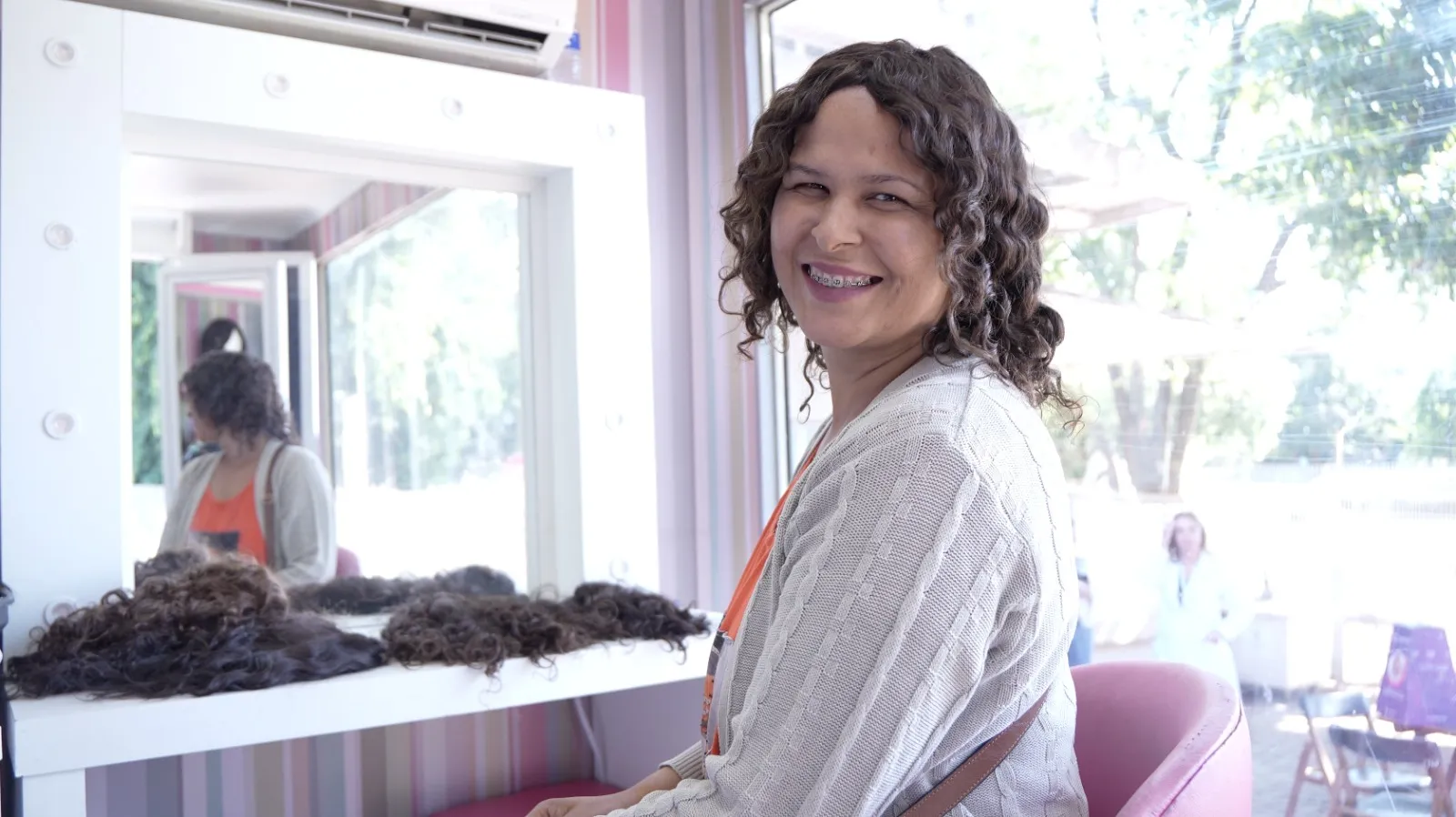 Mulher com câncer feliz usando peruca, autoestima recuperada