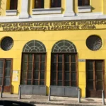 Mão de bebê recém-nascido sendo segurada por mão de adulto, simbolizando proteção e cuidado parental