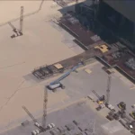 Palco do show da Shakira em Copacabana, ampliado e iluminado, com público na praia.